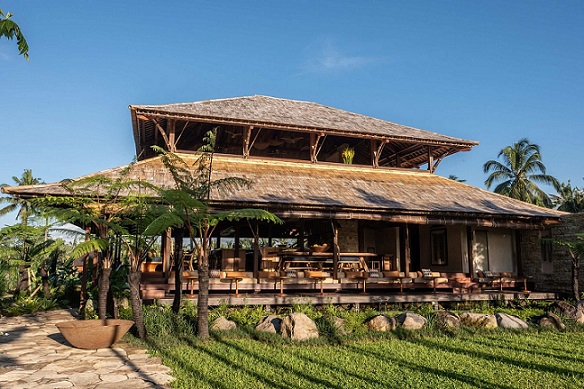 An open-air pavilion surrounded by lush greenery, showcasing traditional Balinese architecture with a serene and natural ambiance